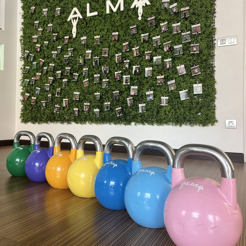 Kettlebells de distintos pesos frente al mural de Alma Entrenamientos