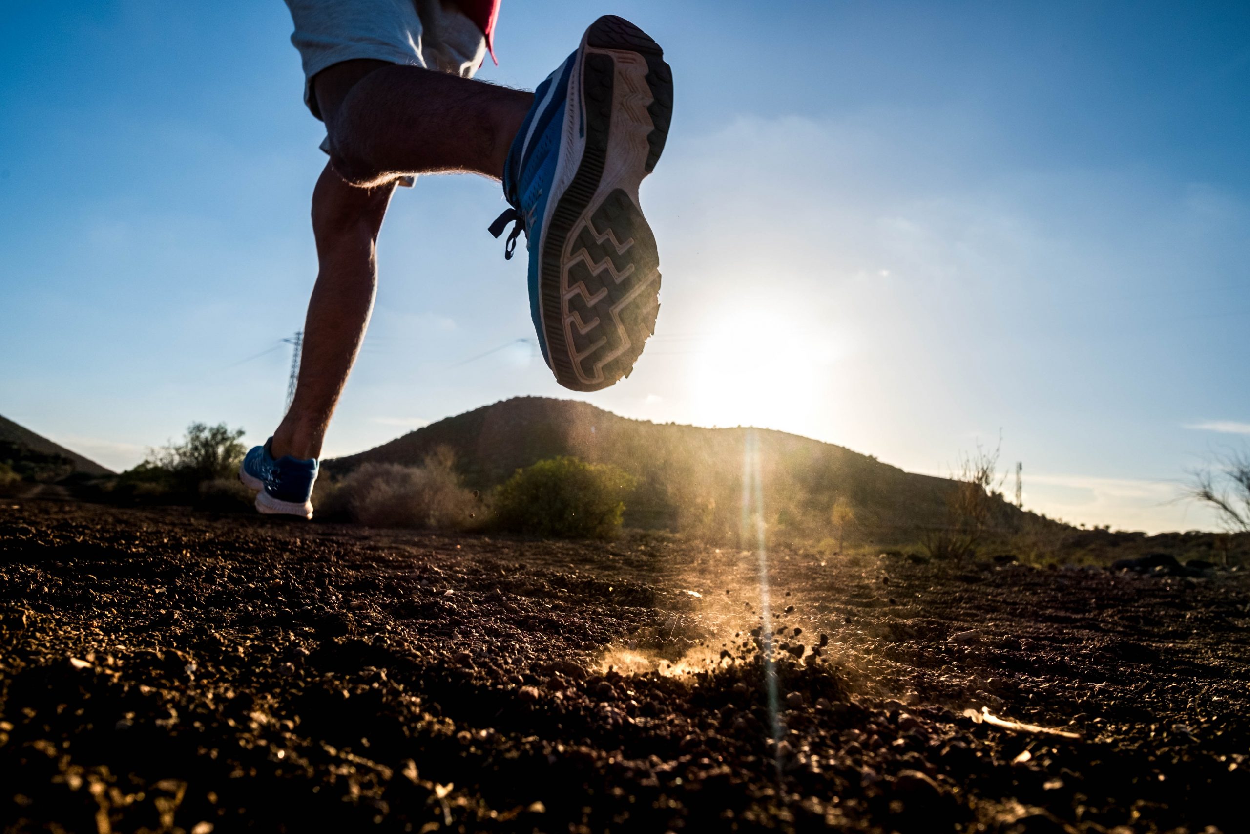 close up of foot of man running alone in the mountains - active and fitness people lifesyle and concept - jogging and loss weight